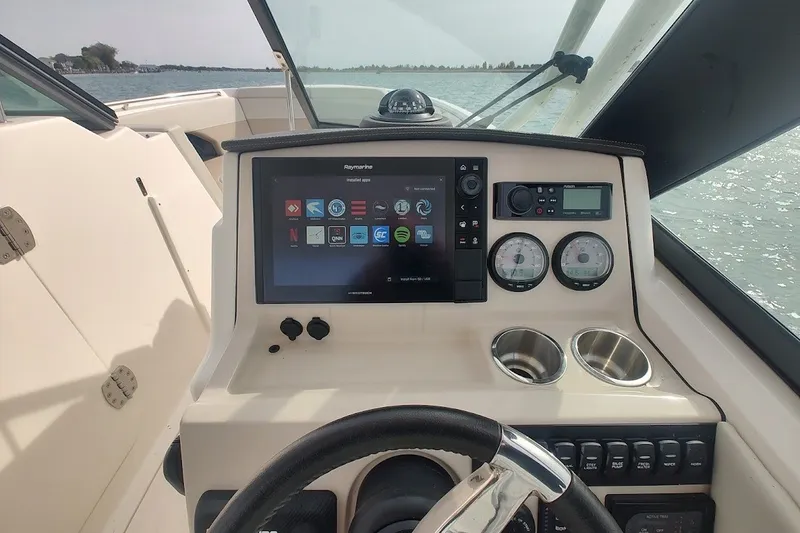 Slide: The Image of Boston Whaler 240 Vantage 2022 dashboard with navigation screen and controls on open water. - 31