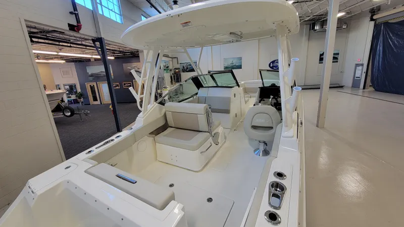 Slide: The Image of Boston Whaler 240 Vantage 2022 in einer Halle, mit geräumigem Cockpit und Sitzbereich. - 2