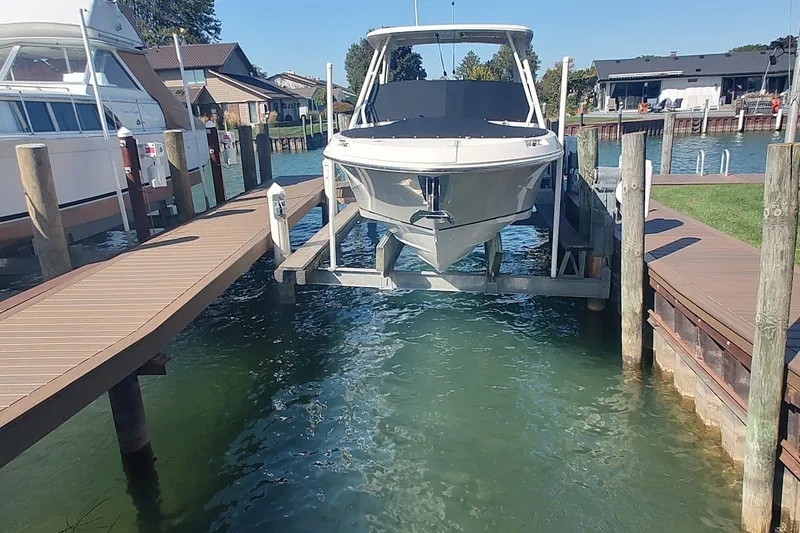 Slide: The Image of 2022 Boston Whaler 240 Vantage boat docked on a lift in a marina. - 28