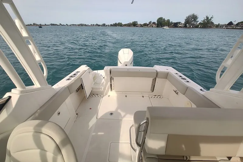 Slide: The Image of 2022 Boston Whaler 240 Vantage boat interior with seating, on a calm lake. - 33