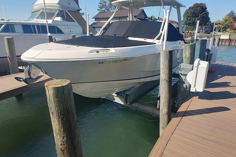 The Image of 2022 Boston Whaler 240 Vantage boat docked on a lift at a marina. - 26