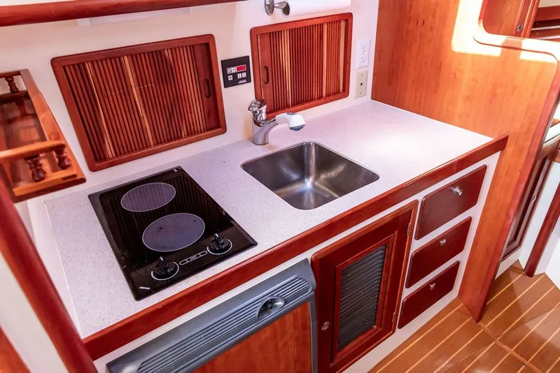 Slide: The Image of Little Harbor WhisperJet 38 (2000) galley with stove, sink, and wooden cabinetry. - 20