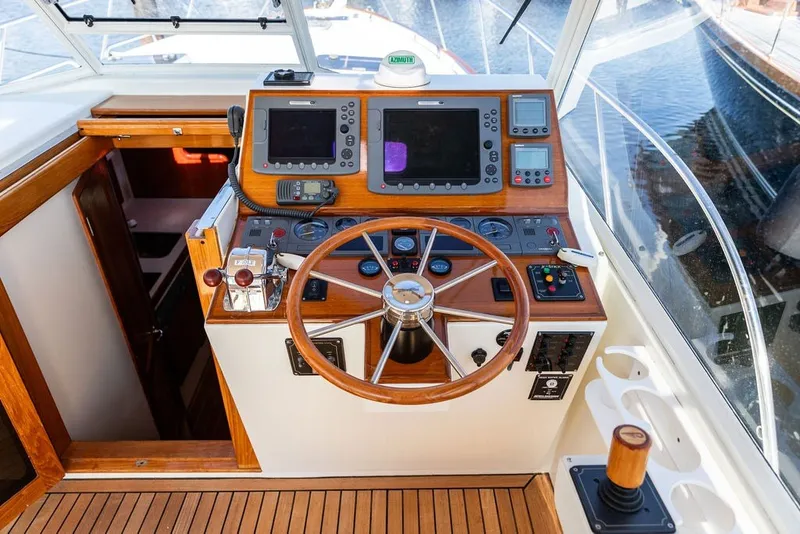 Slide: The Image of Helm of 2000 Little Harbor WhisperJet 38 with wooden steering wheel and navigation instruments. - 14