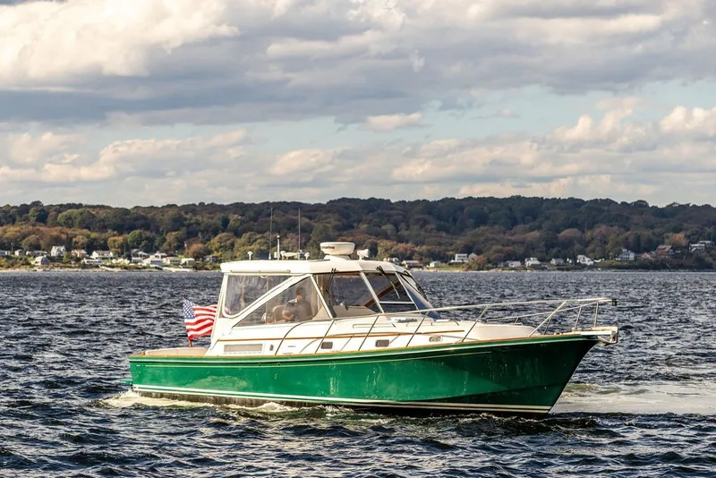 The Image of Little Harbor WhisperJet 38 boat cruising on water, 2000 model, with scenic shoreline backdrop. - 0
