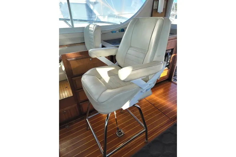 Slide: The Image of Captain's chair on 2005 Compton 33 Downeast Express HT boat, featuring wooden flooring. - 40