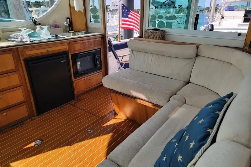 Slide: The Image of Interior of 2005 Compton 33 Downeast Express HT with cozy seating and kitchenette. - 7