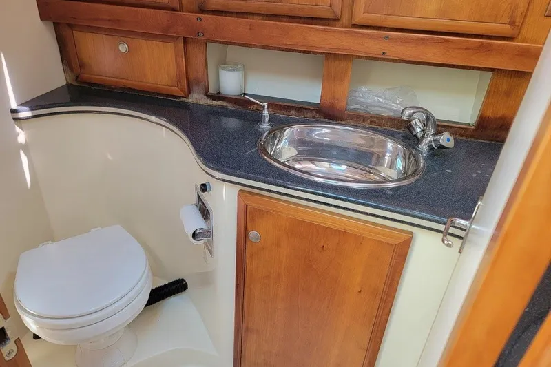 Slide: The Image of Compact bathroom in 2005 Compton 33 Downeast Express HT boat with sink and toilet. - 14