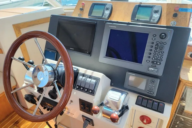 Slide: The Image of Helm of 2005 Compton 33 Downeast Express HT with navigation equipment and wooden steering wheel. - 6