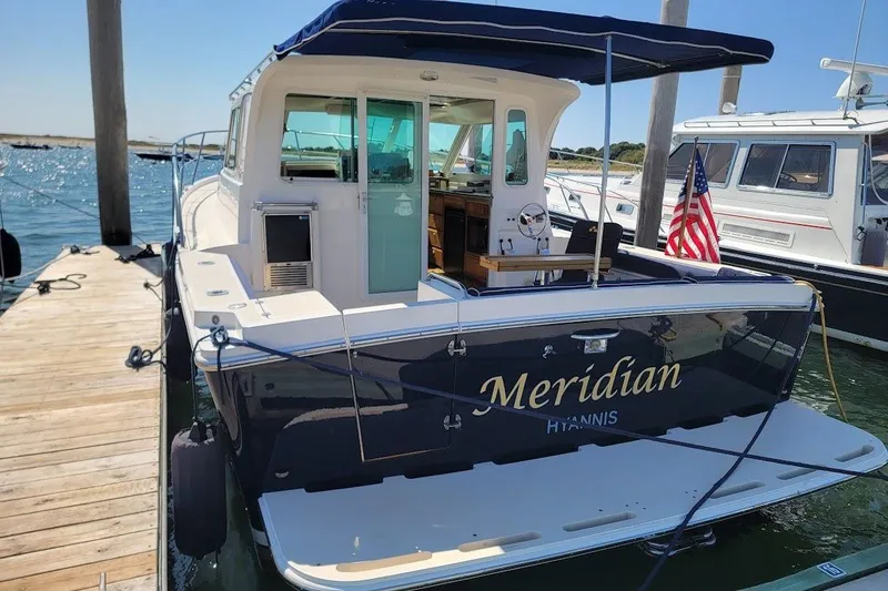Slide: The Image of 2005 Compton 33 Downeast Express HT docked, featuring "Meridian" name and American flag. - 32