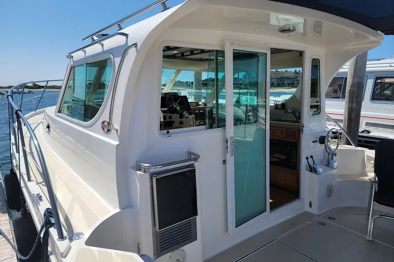 Slide: The Image of 2005 Compton 33 Downeast Express HT yacht docked, showcasing sleek design and spacious interior. - 31