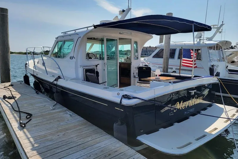 Slide: The Image of 2005 Compton 33 Downeast Express HT docked, featuring sleek design and American flag. - 18