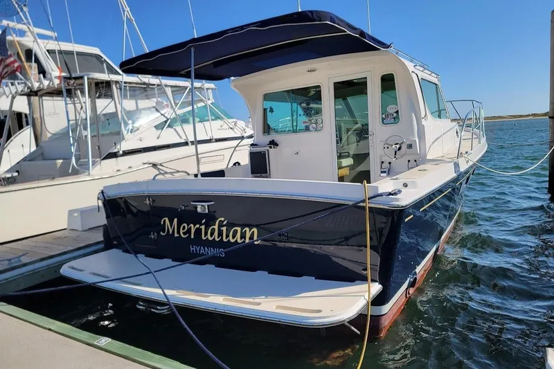 Slide: The Image of 2005 Compton 33 Downeast Express HT boat docked, named "Meridian," in a marina setting. - 25