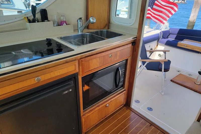 Slide: The Image of Interior of 2005 Compton 33 Downeast Express HT boat with kitchenette and outdoor seating. - 8