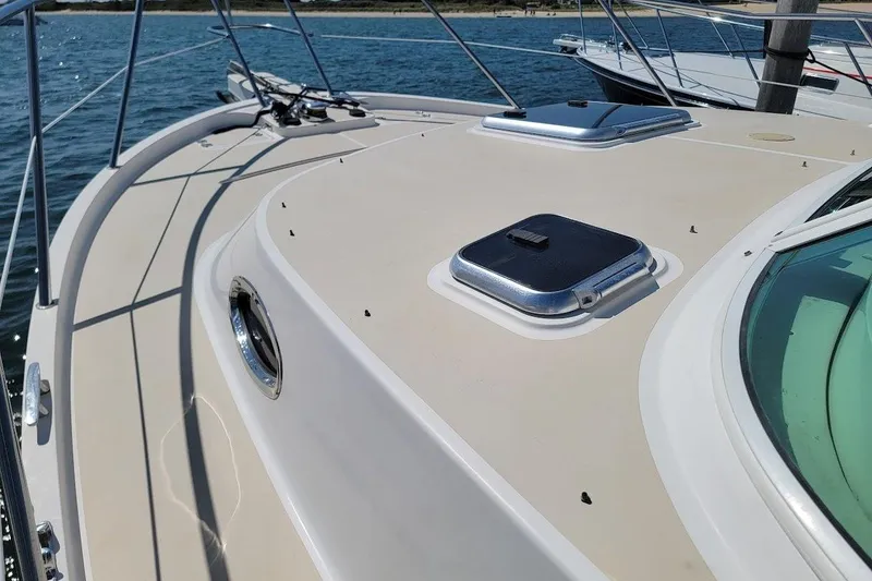Slide: The Image of 2005 Compton 33 Downeast Express HT boat deck with hatches, docked by the water. - 29