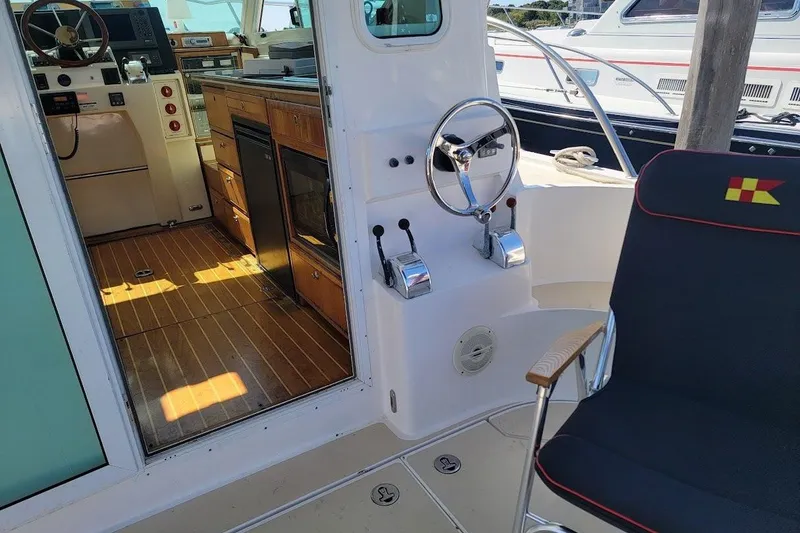 Slide: The Image of Interior of 2005 Compton 33 Downeast Express HT boat with helm and seating area. - 27