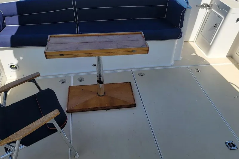 Slide: The Image of 2005 Compton 33 Downeast Express HT boat interior with seating and wooden table. - 22