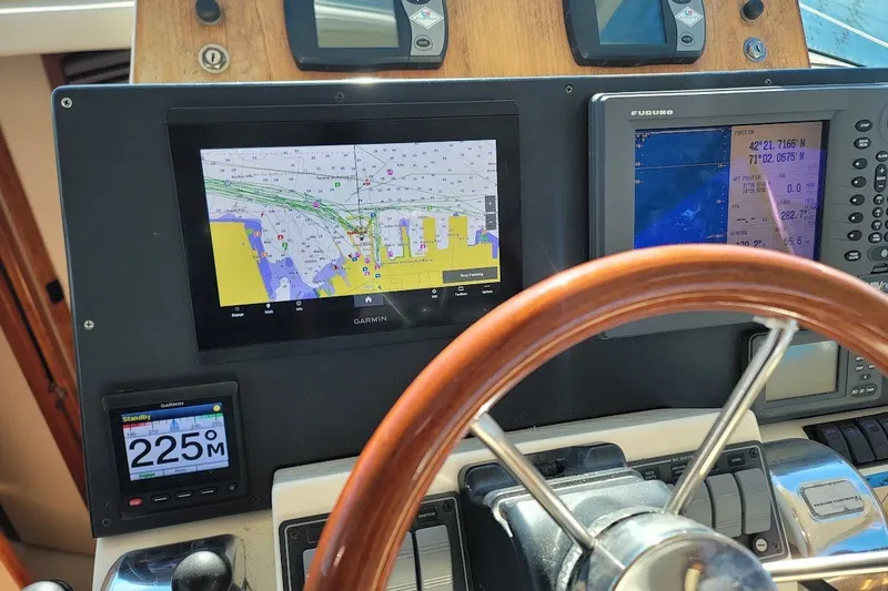 Slide: The Image of Helm of 2005 Compton 33 Downeast Express HT with navigation screens and wooden steering wheel. - 38