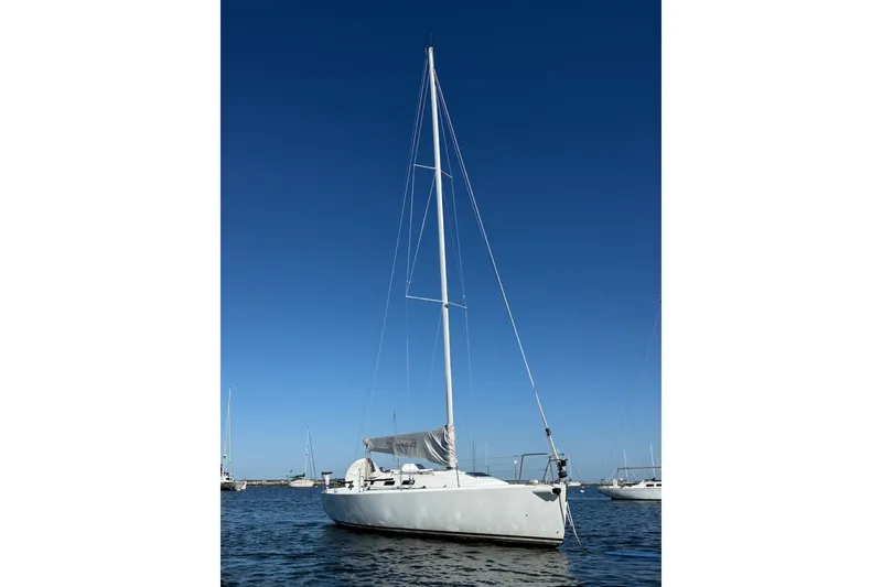 Slide: The Image of 2004 J Boats J/109 sailboat on calm water under clear blue sky. - 2