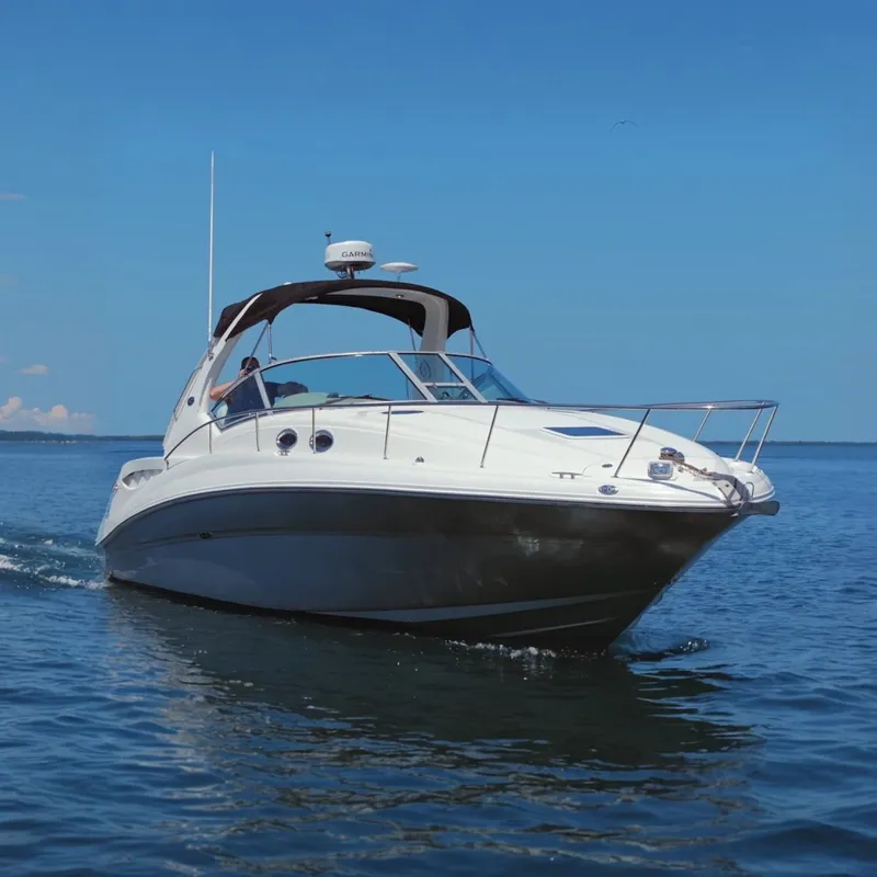 The Image of 2006 Sea Ray Sundancer 320 cruising on open water under clear blue sky. - 0