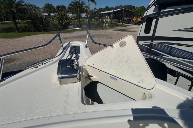 Slide: The Image of 2001 Pursuit 3070 Center Console boat with open storage compartment, parked outdoors. - 50