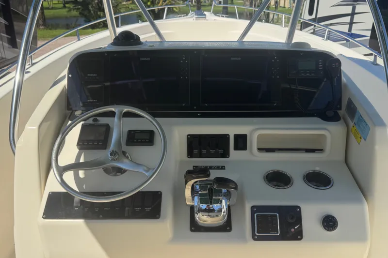 Slide: The Image of Control panel of a 2001 Pursuit 3070 Center Console boat with steering wheel and instruments. - 25