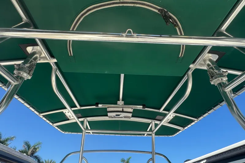 Slide: The Image of 2001 Pursuit 3070 Center Console boat with green canopy and metal framework. - 61