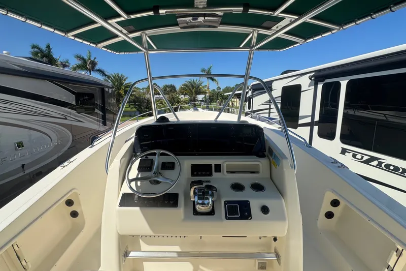 Slide: The Image of The image shows the cockpit of a 2001 Pursuit 3070 Center Console boat with a green sunshade. - 23