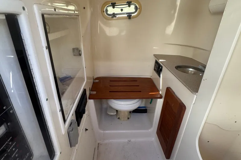 Slide: The Image of 2001 Pursuit 3070 Center Console boat interior with compact bathroom and sink. - 35