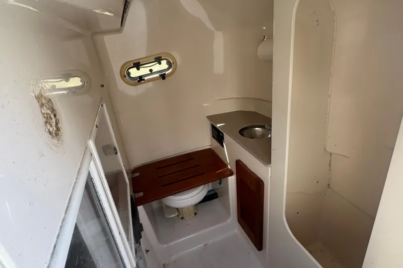Slide: The Image of 2001 Pursuit 3070 Center Console boat interior with compact bathroom and sink. - 36