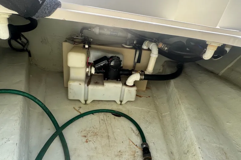 Slide: The Image of Bilge area of a 2001 Pursuit 3070 Center Console boat with hoses and pump system. - 76