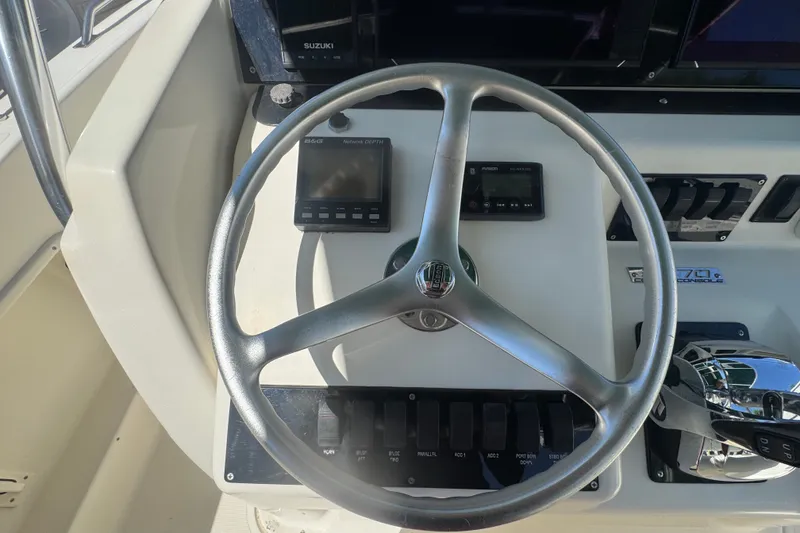 Slide: The Image of Steering wheel and controls of a 2001 Pursuit 3070 Center Console boat. - 27
