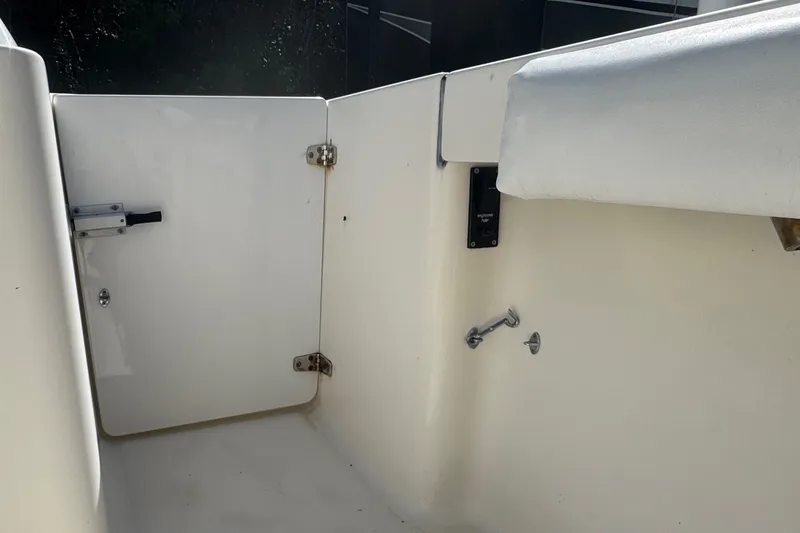 Slide: The Image of Interior view of a 2001 Pursuit 3070 Center Console boat, featuring a white door and seating. - 14