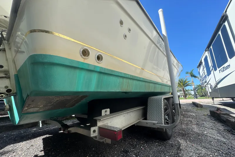 Slide: The Image of 2001 Pursuit 3070 Center Console boat on trailer, parked outdoors under clear blue sky. - 66