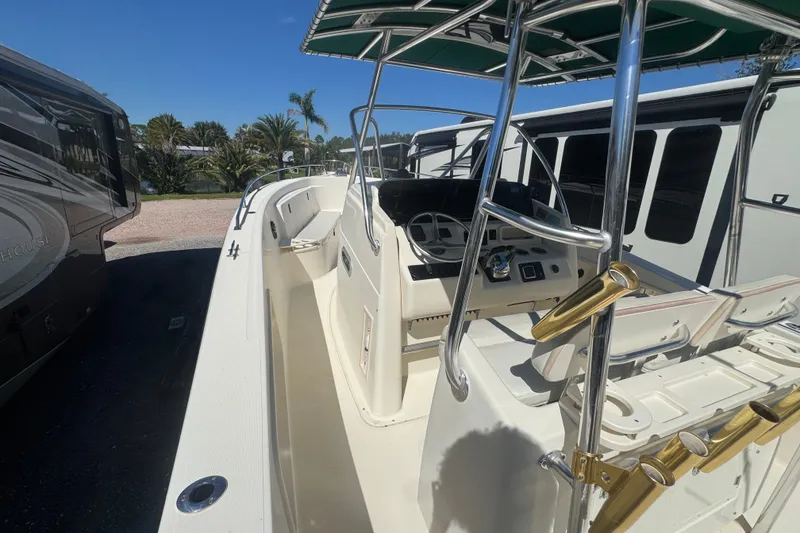 Slide: The Image of 2001 Pursuit 3070 Center Console boat with helm, rod holders, and seating under a sunny sky. - 40