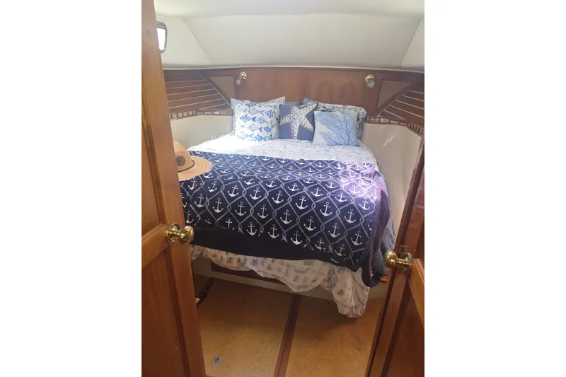 Slide: The Image of Cozy cabin interior of 1981 Lancer Motor Sailer with nautical-themed bedding and pillows. - 14
