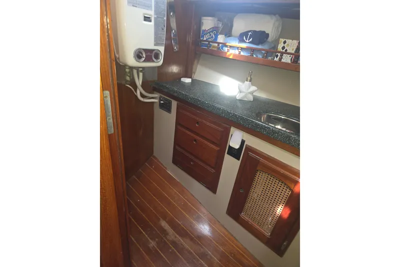 Slide: The Image of Interior of 1981 Lancer Motor Sailer with wooden cabinetry and compact sink area. - 16