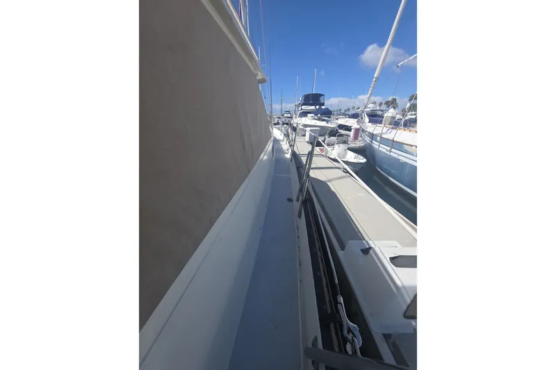 Slide: The Image of 1981 Lancer Motor Sailer docked at marina under clear blue sky. - 21