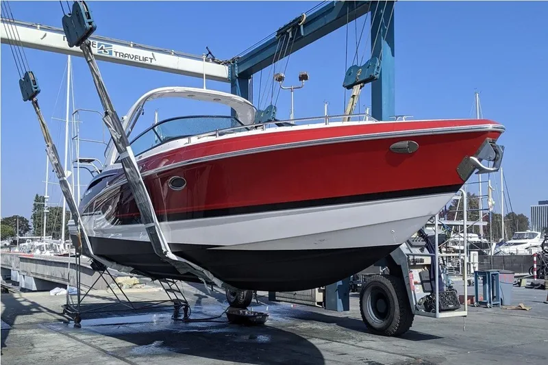 Slide: The Image of 2019 Formula 310 Bowrider in red, lifted by a boat hoist at a marina. - 15