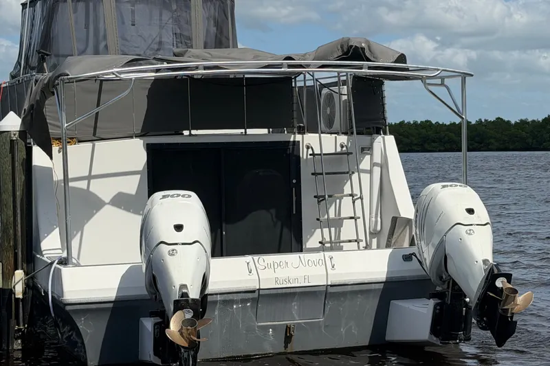 Slide: The Image of 1987 Bluewater Yachts Coastal Cruiser 51 docked, featuring dual outboard motors. - 14