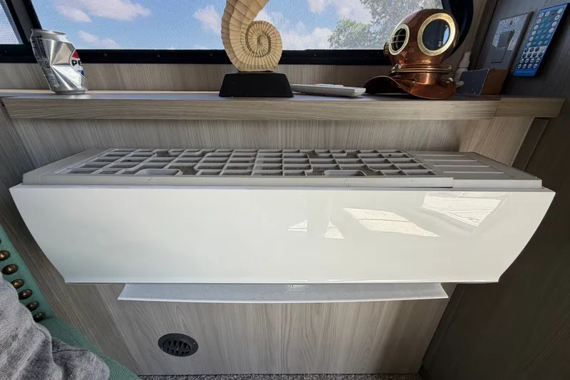 Slide: The Image of Interior of 1987 Bluewater Yachts Coastal Cruiser 51 with decorative items and air conditioning unit. - 28