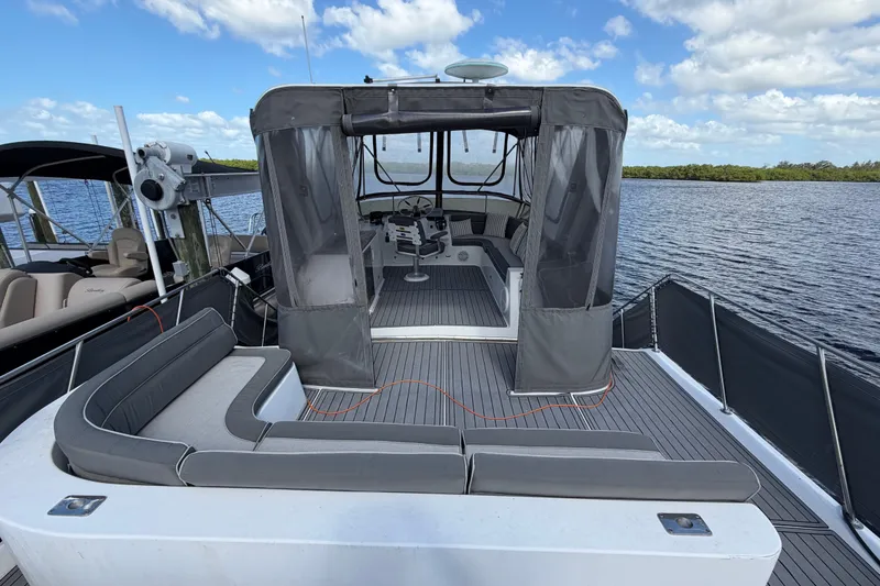 Slide: The Image of 1987 Bluewater Yachts Coastal Cruiser 51, spacious deck with seating, docked by calm waters. - 52