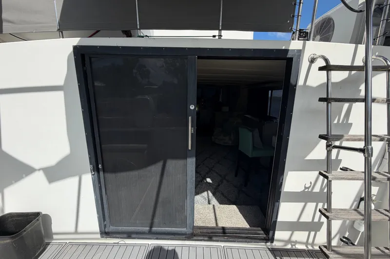 Slide: The Image of 1987 Bluewater Yachts Coastal Cruiser 51, featuring a sliding glass door and exterior ladder. - 23