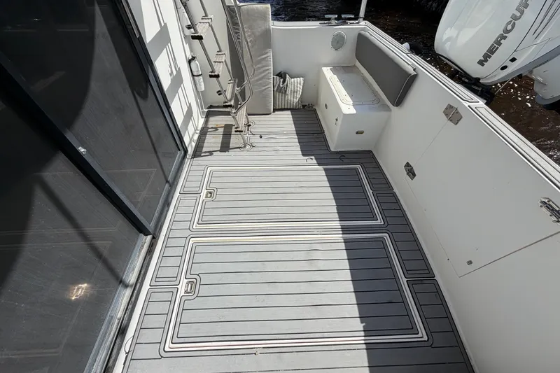Slide: The Image of 1987 Bluewater Yachts Coastal Cruiser 51 deck with seating and storage, featuring modern flooring. - 21