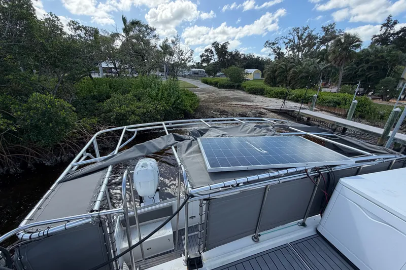 Slide: The Image of 1987 Bluewater Yachts Coastal Cruiser 51 with solar panel, docked near lush greenery. - 53