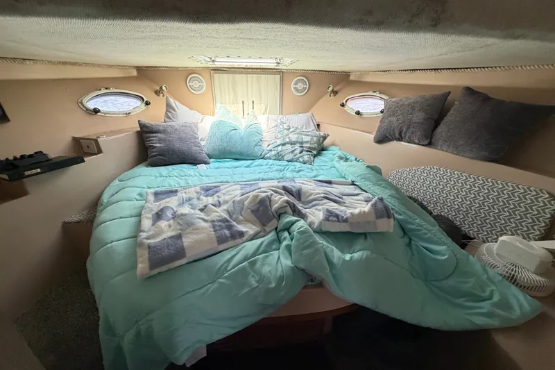 Slide: The Image of Cozy bedroom in 1987 Bluewater Yachts Coastal Cruiser 51 with teal bedding and pillows. - 45