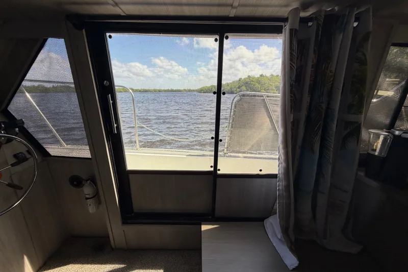 Slide: The Image of Interior view from 1987 Bluewater Yachts Coastal Cruiser 51, overlooking serene waters and lush greenery. - 48