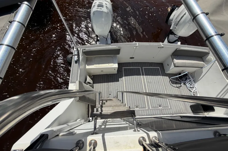 Slide: The Image of 1987 Bluewater Yachts Coastal Cruiser 51 deck view with outboard motors and seating area. - 54
