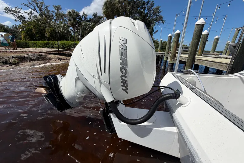 Slide: The Image of Outboard motor on 1987 Bluewater Yachts Coastal Cruiser 51, docked by a wooden pier. - 16