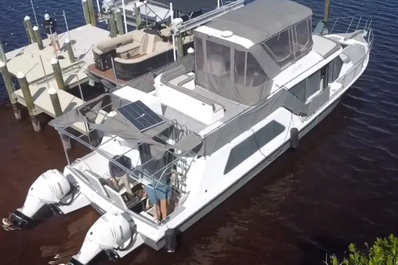 Slide: The Image of 1987 Bluewater Yachts Coastal Cruiser 51 docked, featuring dual outboard motors and solar panel. - 2