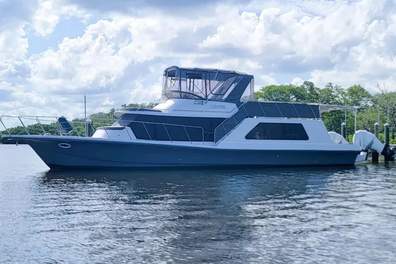 The Image of 1987 Bluewater Yachts Coastal Cruiser 51 on calm water under a cloudy sky. - 1